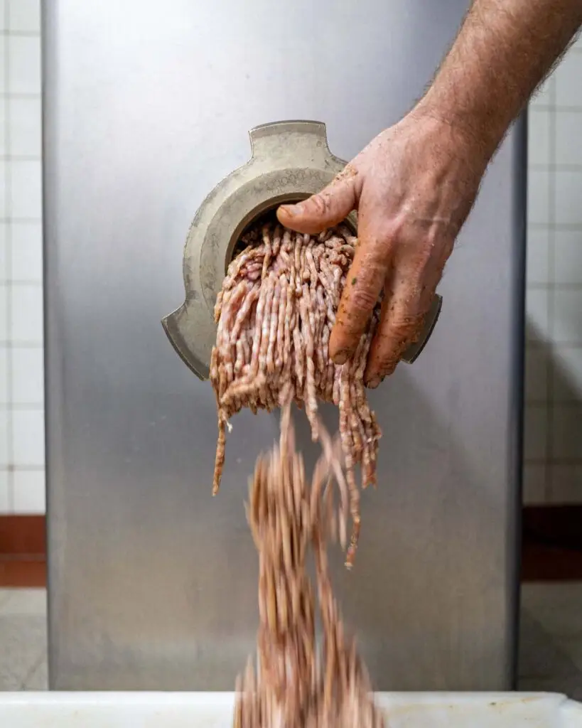 Frisches Brät aus dem Fleischwolf bei der handwerklichen Wurstherstellung in der Metzgerei Hornung Bamberg