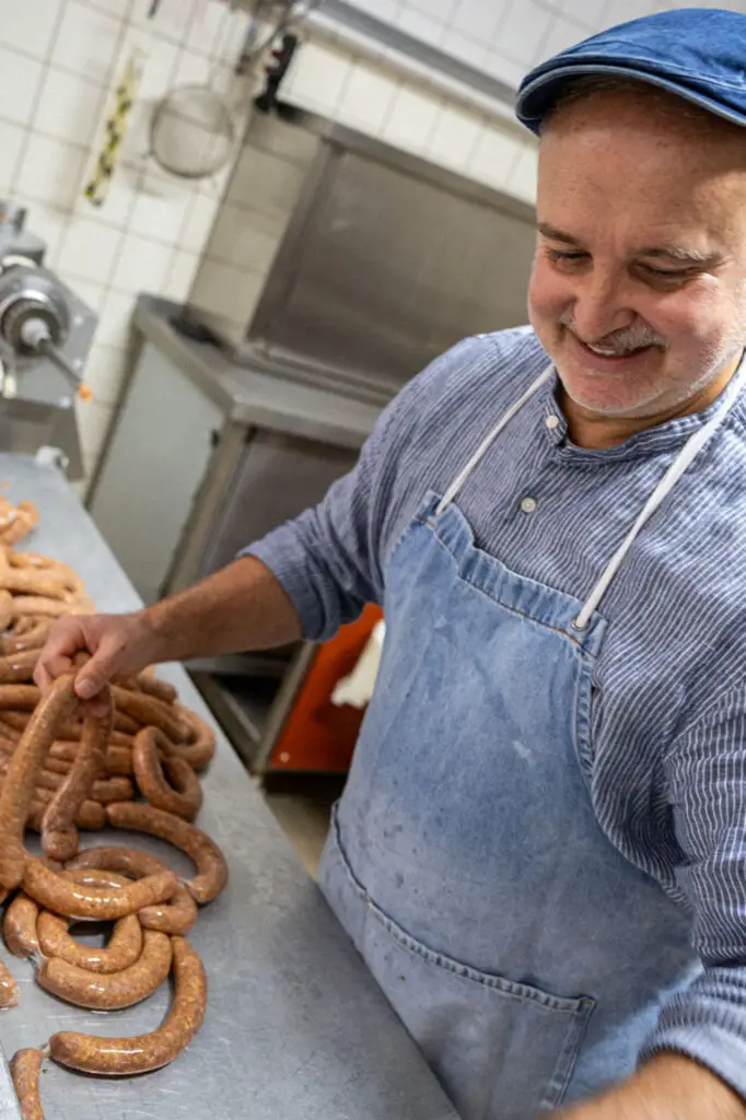 Mitarbeitender der Metzgerei Hornung in Bamberg bei der handwerklichen Herstellung frischer Bratwürste