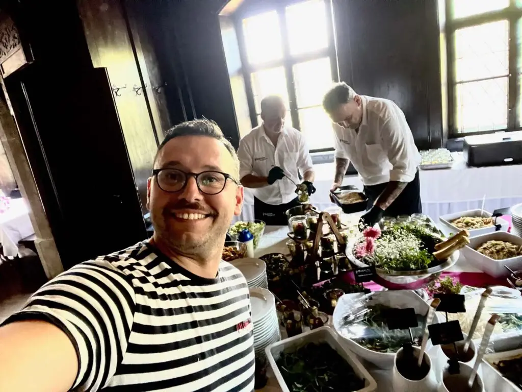 Mitarbeitender der Metzgerei Hornung Bamberg vor einem Buffet mit fränkischen Spezialitäten