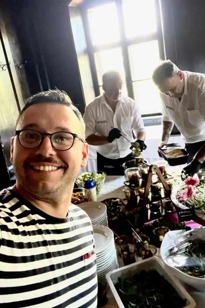 Mitarbeitender der Metzgerei Hornung Bamberg vor einem Buffet mit fränkischen Spezialitäten bei einem Catering-Einsatz